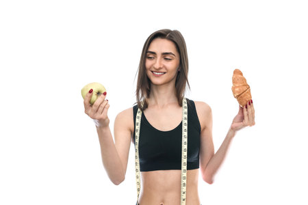 Woman with apple and croissant isolated on whiteの写真素材