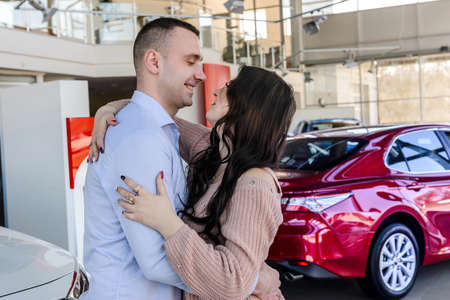 Man making surprise for his wife in avto salonの写真素材