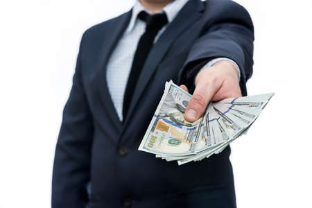 Man in suit holding pile of dollar banknotes