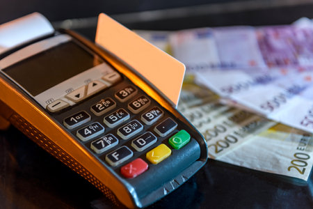 Terminal with card and euro banknotes behind itの写真素材