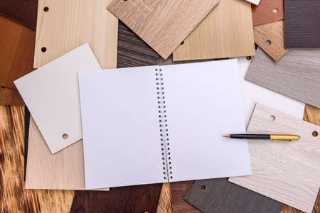 Notepad and pen with wooden swatch on tableの写真素材