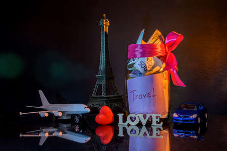 Savings for traveling with toy eiffel tower on dark backgroundの写真素材