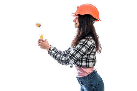 Young woman in helmet holding roller isolated on white