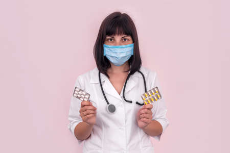 Doctor in mask showing pills in blisterの写真素材