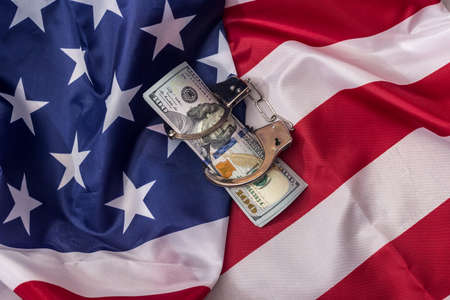 American dollars in handcuffs on national flagの写真素材