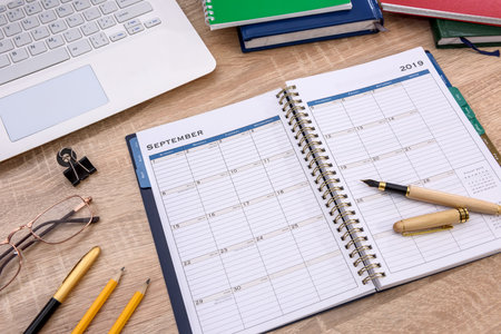 Opened notepad with laptop on wooden table