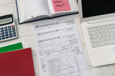'Need help' text on 1040 form and laptopの写真素材