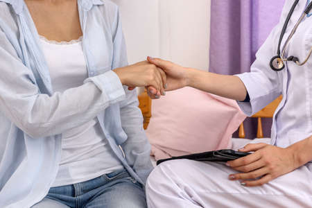 Visiting hospital. Female handshakes of patient and doctor close upの写真素材