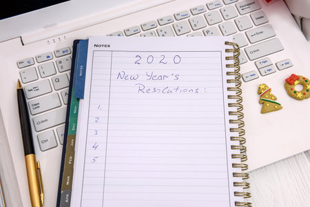 New year resolution in notepad with laptop on table