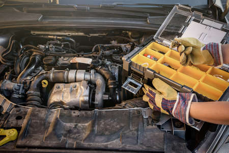 Tool box with hand on car engine close upの写真素材