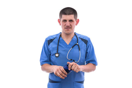 young doctor in blue uniform takes pills from jars isolated on white backgroundの写真素材