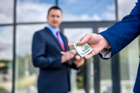 Businessmen signing contract with euro banknotes outdoorsの写真素材
