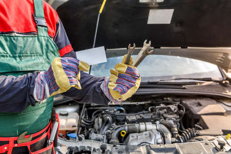 Male hands with spanners and visit card close up