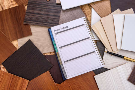 Notepad and pen with wooden swatch on table
