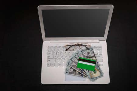 Dollars with credit card on laptop keyboard