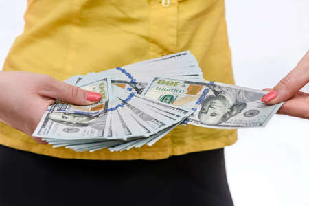 Female hand offering dollar banknotes in fan