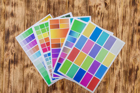 Colored paper samplers on wooden table.