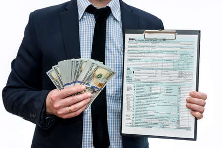 Man showing 1040 tax form and dollars in fanの写真素材