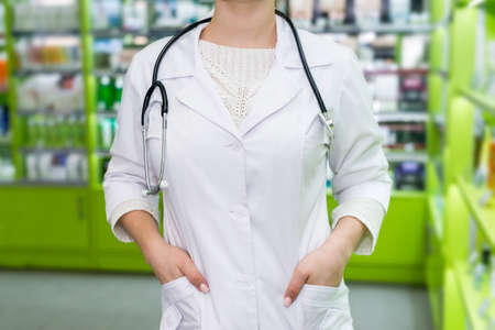 Pharmacist standing in drugstore, hands in pocket robeの写真素材