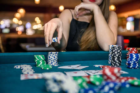 Female hand taking poker chips from pileの写真素材