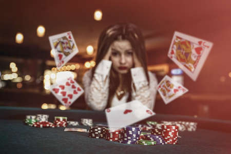 Upset woman in casino with falling cardsの写真素材