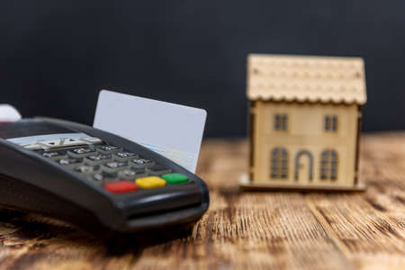 Terminal with credit card and wooden house model