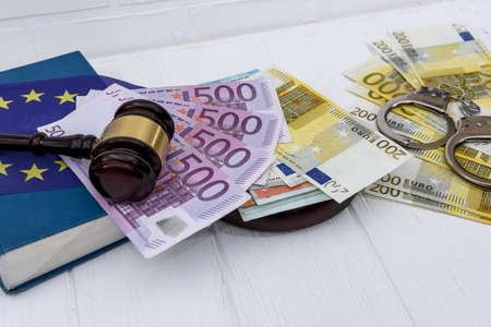 Handcuffs with euro banknotes and judge's gavelの写真素材