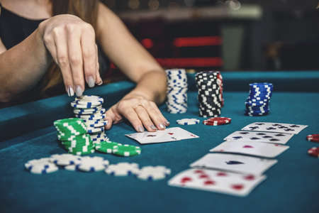Beautiful woman in casino taking chips from pile