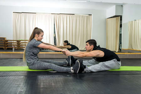 Pair training in gym, man and woman doing exercise