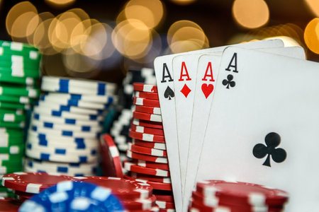 Poker chips with four aces at table in casino