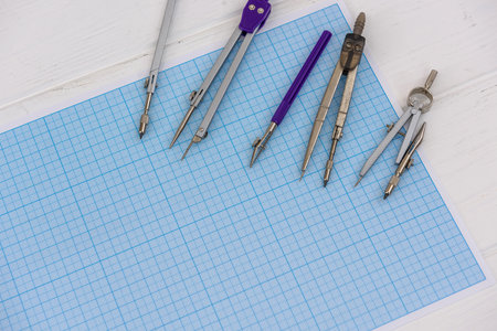 Millimeter paper with draughtsmanship equipment at the table