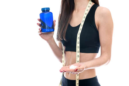 Young slim woman offering pills from bottleの写真素材