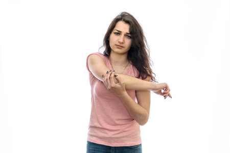 Woman holding her elbow isolated on white