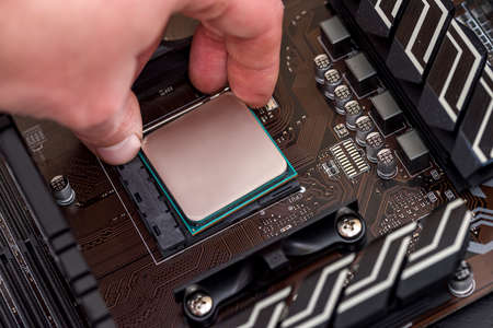 Human hand taking out cpu from motherboard
