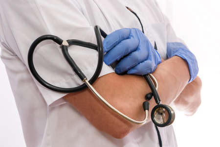 Doctor's hands with stethoscope. Side view of doctor holding stethoscope isolated on whiteの写真素材