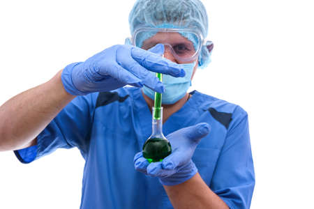 young male lab assistant examining green liquid in test tube