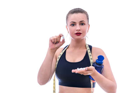 Sportive woman with pills and bottle isolated on whiteの写真素材