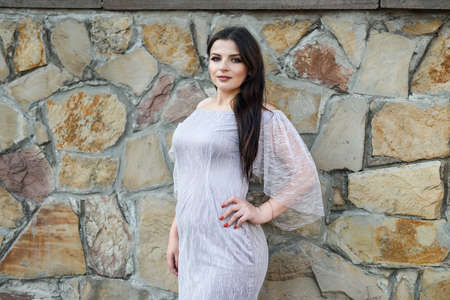Beautiful brunette woman wearing fashion dress. Fashion city photo.の写真素材
