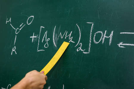 Female hand pointing at chemical formula on blackboard close upの写真素材