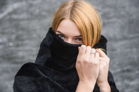 Urban fashion. Portrait of fashion woman in fur coat posing on city streetの写真素材