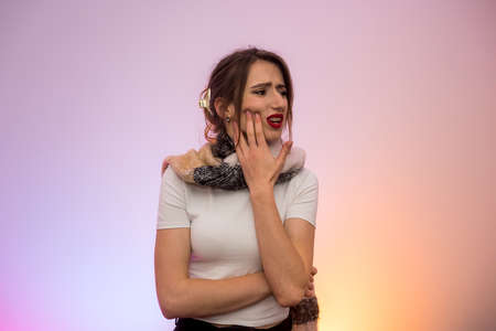 Woman suffering with toothache. She's holding her hand on face and feeling pain