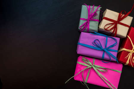 Colorful gift boxes on dark background. Celebration of new year and Christmas