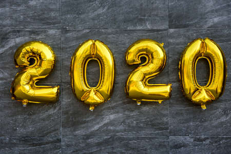 Golden air balloons 2020 on gray background. New year celebration with balloonsの写真素材