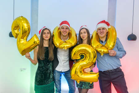 Group of friends with 2020 air balloons celebrating New Year