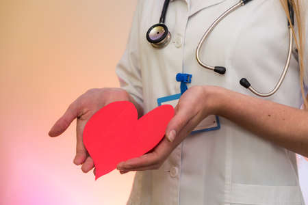 Doctor holding red heart. Cardiologist with heart shape in hands close upの写真素材