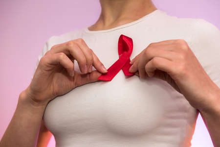 Female hands close up with red ribbon. AIDS company concept. Social advertisingの写真素材