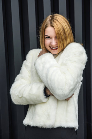 Elegant woman in little black dress and with fur scarf posing outside. Fashion conceptの写真素材