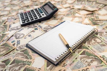 Empty notepad with calculator on Ukrainian Money backgrounds. 500 banknotes. Hryvnia (UAH). Top...