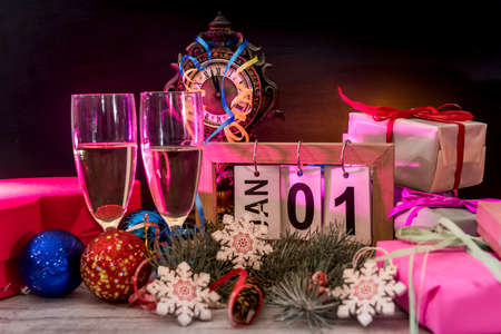 Wooden calendar with champagne glasses and new year decorations on wooden table
