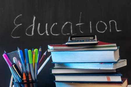 education word on chalkboard with school books on desk, education concept.